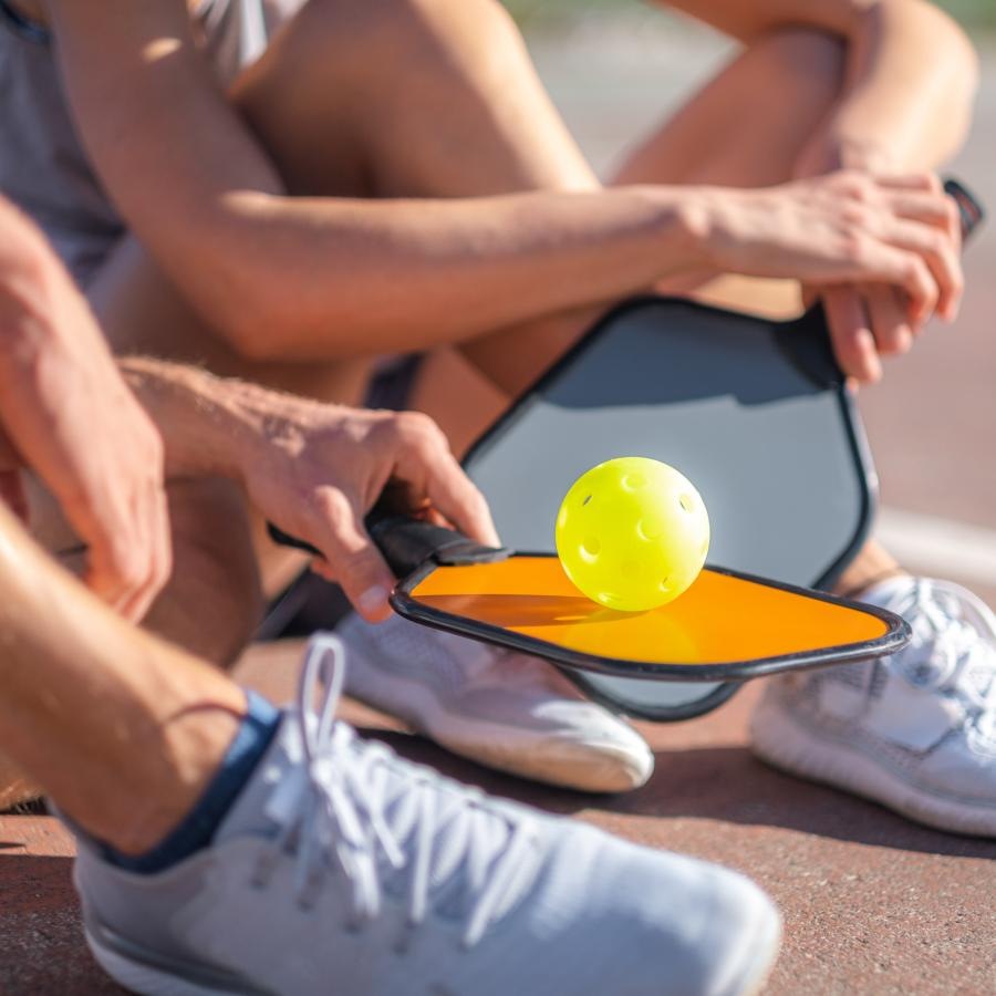 a group of people sitting on the ground with a tennis ball